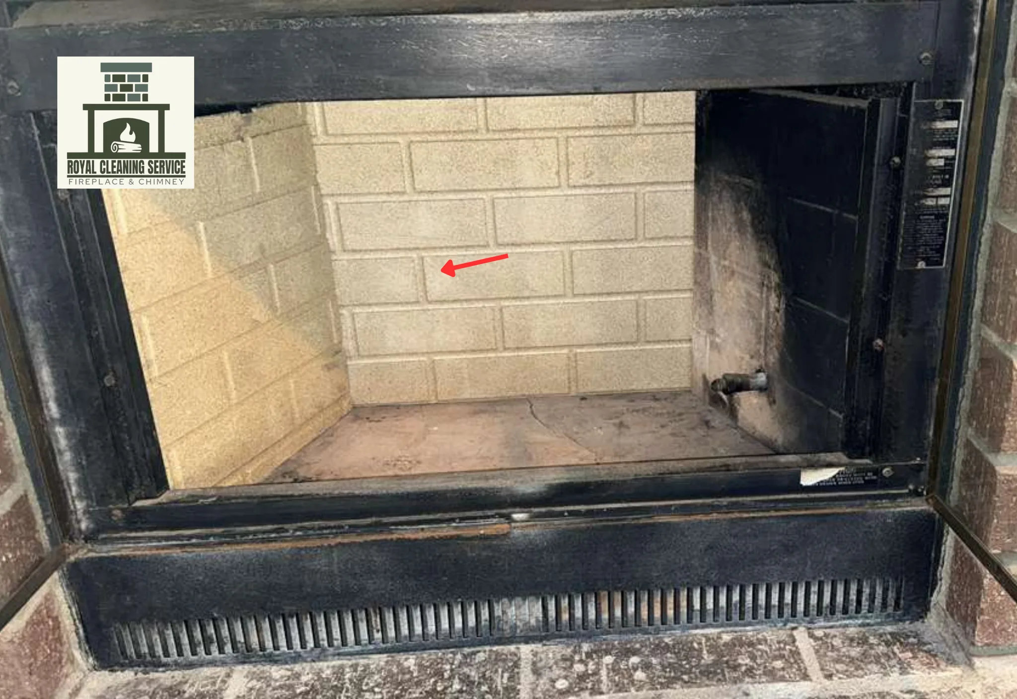 Technician cleaning soot from a residential fireplace opening