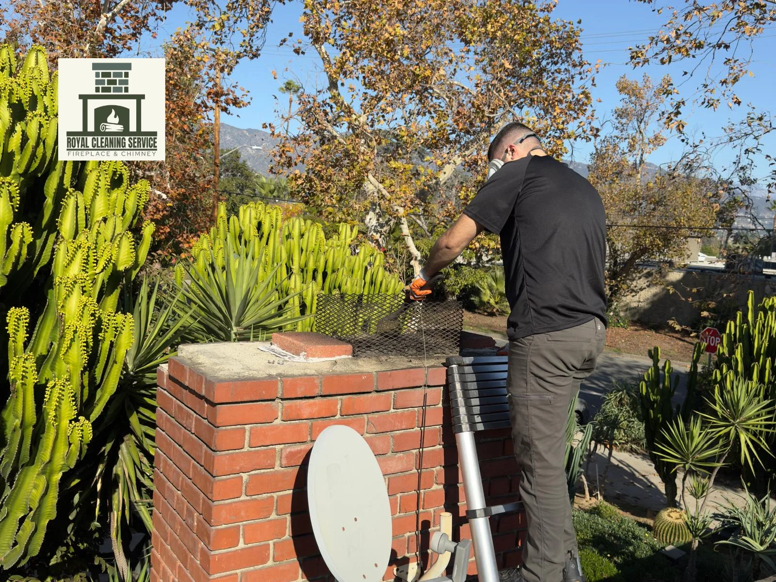 Technician standing beside a residential chimney during annual sweep service