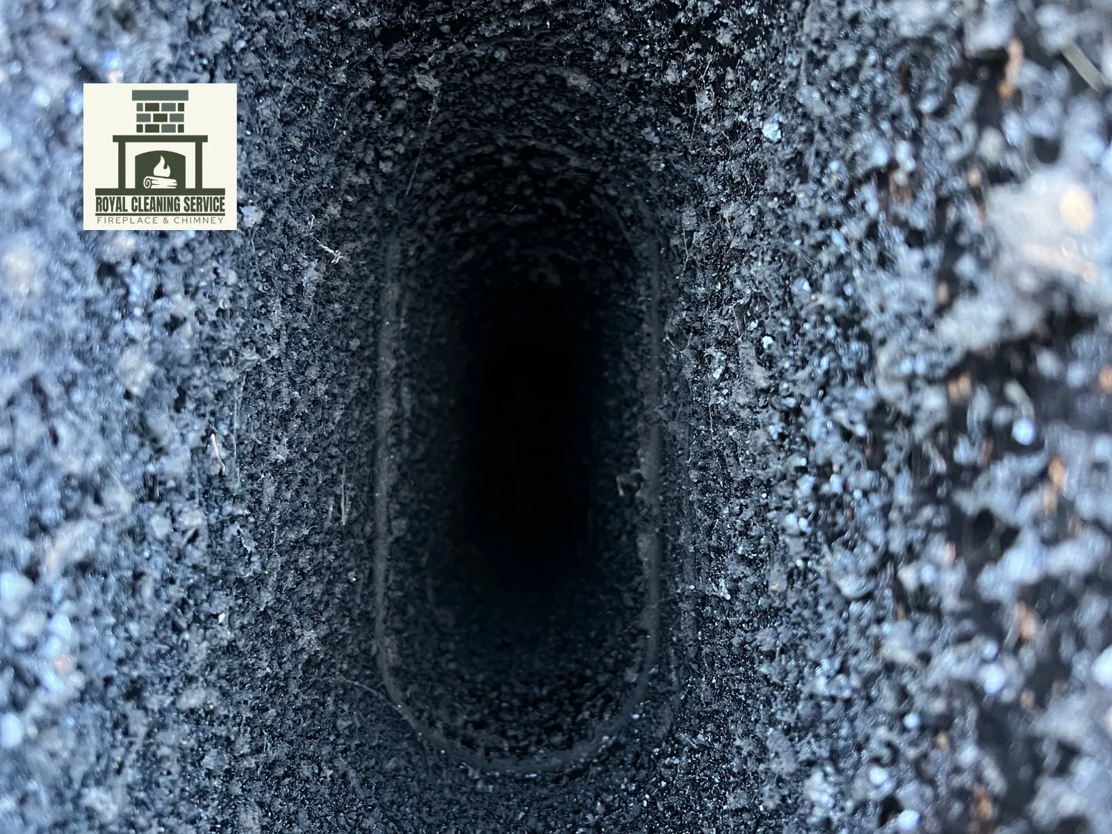 Close-up view inside a chimney flue showing heavy creosote buildup